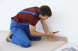 © Africa Studio - Worker using cutter while installing new carpet flooring in room