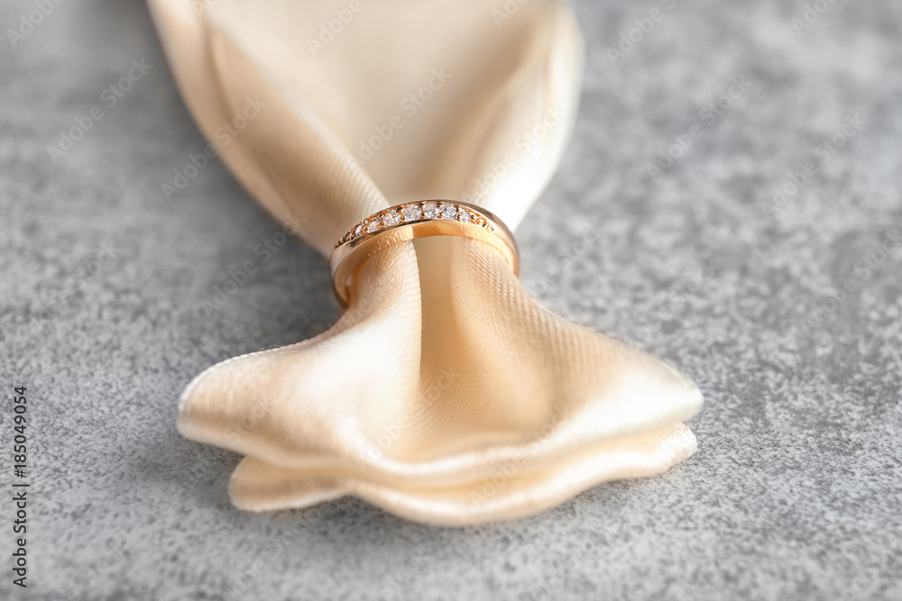 Ribbon with beautiful engagement ring on table