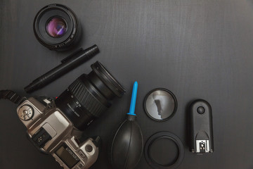 Wall Mural - top view of work space photographer with dslr camera system, camera cleaning kit and camera accessory on black table background with copy space