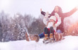 © alexkich - A winter fairy tale, a young mother and her daughter ride a sled