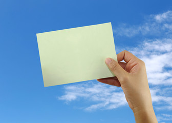 hand of a businessman holding a blank green note paper.