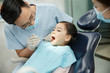 © View Stock - The dentist and the dentist's assistant are examining the tooth for the little girl