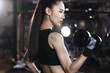 © View Stock - Young woman lifting dumbbell in gym
