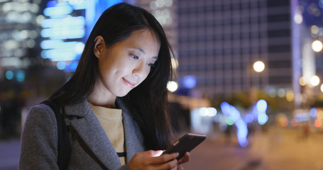 Wall Mural - Woman look at mobile phone in city at night