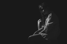 The Depression Woman Sit On The Chair On Dark Background, Sad  Asian Woman Silhouette In Dark, Monochrome Image. Free From Copy Space.