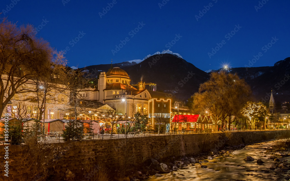 Meran Merano in South Tyrol, Italy, during the Christmas with christmans market by night . Beautiful light and great atmosphere - obrazy, fototapety, plakaty 