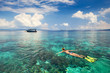 © soft_light - Woman snorkeling in clear tropical waters on a background of islands