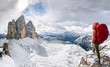 hiker with knapsack look on panorama view of Dolomites mountain in Italy at sunset. Tre Cime di Lavaredo mountain.