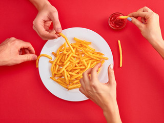 Young woman eating french fries potato with ketchup in a restaurant