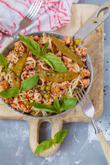 Wall Mural - Homemade pasta with meat, green peas and basil in a frying pan