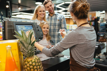 Wall Mural - Beautiful family paying for their groceries