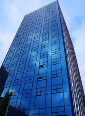 Reflection of clouds in facade of building