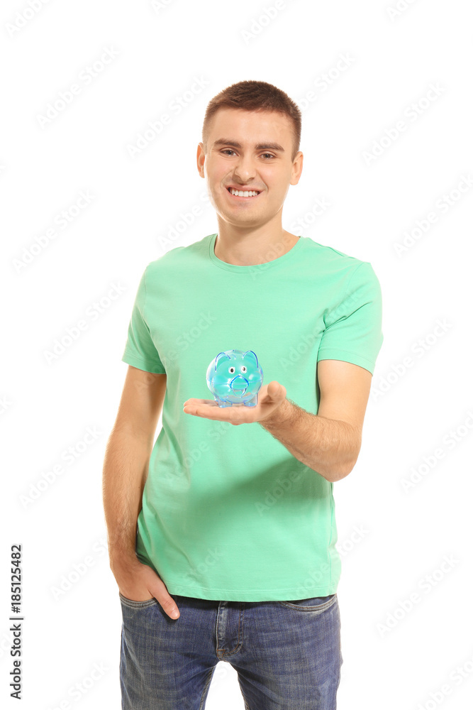 Young man holding piggy bank on white background