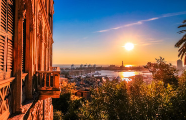 genoa cityscape, with traditional genoese architecture and harbor with cranes during sunset.