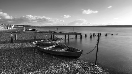 Wall Mural - Beautiful black and white sunset landscape image of boats moored in Fleet Lagoon in Dorset England