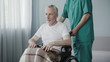 © motortion - Worker of rehabilitation center supporting old ill man, advising not to give up