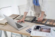 © LUMINA IMAGES - Hands of unrecognisable woman interior designer working with material palette and typing on her laptop.