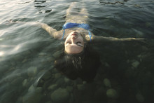 High Angle View Of Carefree Woman With Eyes Closed Floating On Water In River