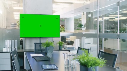 Canvas Print - Modern Empty Meeting Room with Big Conference Table with Various Documents and Laptops on it, on the Wall Big TV with Green Chroma Key Screen. RED EPIC-W 8K Camera.