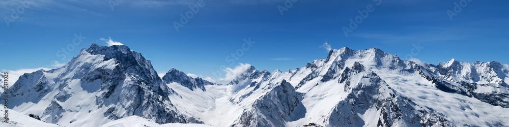 Panoramic view of snow-capped mountain peaks - obrazy, fototapety, plakaty 