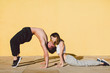 © BONNINSTUDIO/Stocksy - Couple in love doing acrobatics in front of a yellow wall.