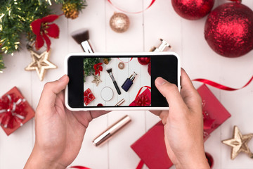 Sticker - Hands holding mobile taking photo of christmas make up cosmetics products