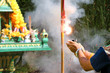 Asian people with firecrackers pay respect to shrine or spirit worship