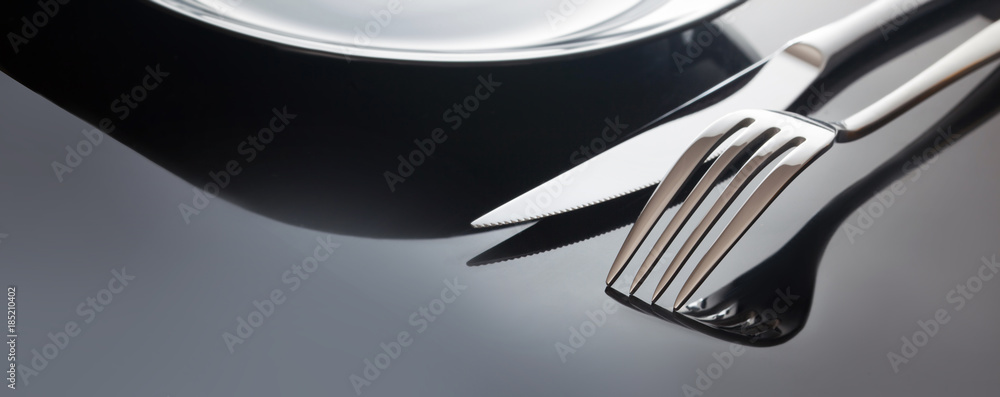Obraz na płótnie Empty plate with knife and fork on a black background w sypialni