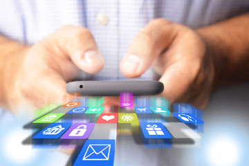 businessman or engineer holding smartphone with falling applications icons