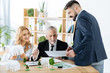 © Viacheslav Yakobchuk - Good news. Professional real estate agents feeling satisfied with the results of their work while sitting in their comfortable equipped office and looking at the important document