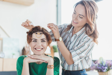 Wall Mural - young women trying on handmade headband at workshop