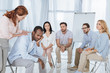 © LIGHTFIELD STUDIOS - psychotherapist supporting african american man during group therapy