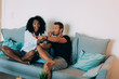 © DavidPrado - Happy young couple relaxed at home in the couch having fun watching tv