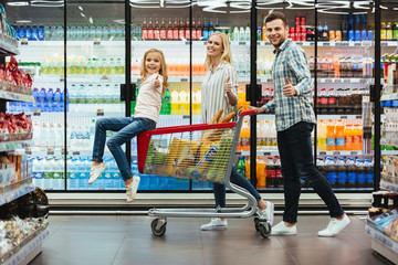 Happy young family with a child sitting on a cart