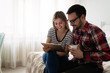 © NDABCREATIVITY - Young attractive couple using tablet in bedroom