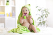 © Oksana Kuzmina - Little baby in green towel biting toy after bath. Infant boy with teether. Child health care.