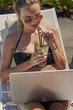 Kobieta pracująca na laptopie. Dziewczyna na wakacjach. Praca w podróży. Praca zdalna.  Na basenie.