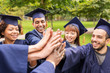 © Syda Productions - happy students in mortar boards making high five