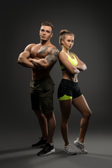 Wall Mural - Sexy young fitness couple shot on gray background