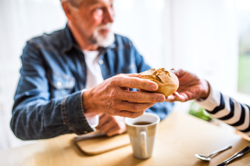 Wall Mural - Senior couple eating breakfast at home.