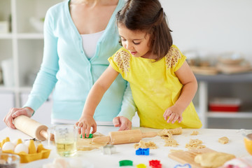 Wall Mural - happy mother and daughter making cookies at home