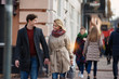 © Yakobchuk Olena - Portrait of young man and woman walking down the street and looking at each other with people on the background