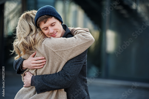 Portrait of young couple hugging each other while standing in the street Poster Mural XXL