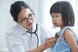 © eggeeggjiew - Female Doctor examining a little girl.