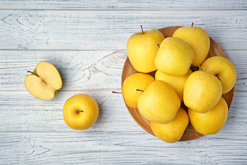 Wall Mural - Ripe yellow apples on wooden background, top view