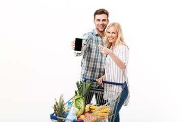 Poster - Portrait of a happy couple showing blank screen mobile phone