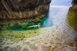 Woman swimming in Angel's Billabong is natural infinity pool on the island of Nusa Penida next to Bali, Indonesia
