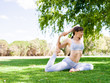 © Sergey Nivens - Young woman practicing yoga in the park