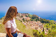 The girl looks from the heights to the city, Sicily, Taormina.No recognizable face