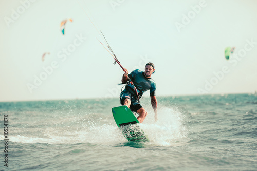 Fototapety Kitesurfing  kitesurfing-zdjecia-akcji-na-kiteboardzie-czlowiek-wsrod-fal-szybko-odchodzi